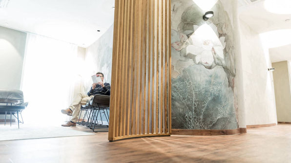 Wartebereich  mit Holzlattentrennung und Wandtattoo