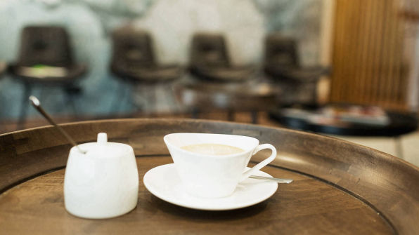 Tasse Kaffee im Vordergrund des Wartezimmers