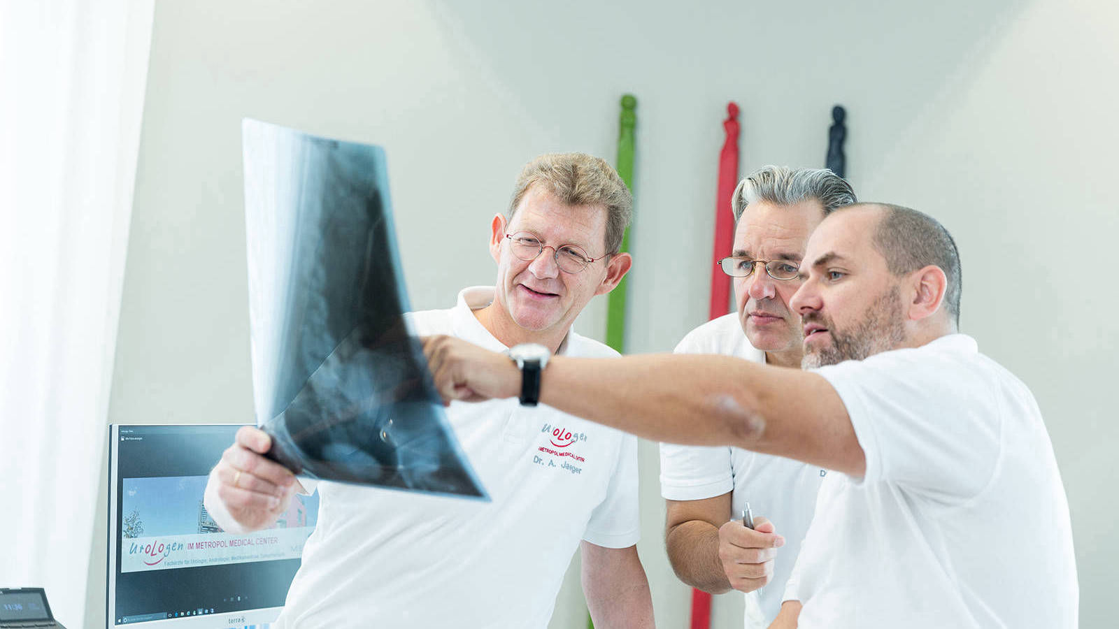 drei Ärzte begutachten ein Röntgenbild